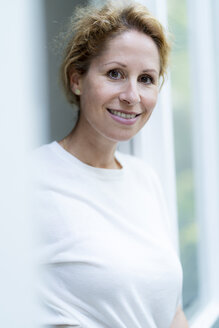 Portrait of smiling woman wearing white t-shirt - HHLMF00508