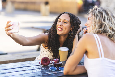 Zwei glückliche Freunde machen ein Selfie am Tisch im Freien - WPEF00787