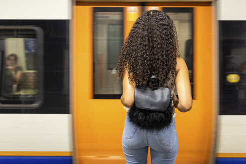Großbritannien, London, Rückansicht einer jungen Frau, die am Bahnsteig einer U-Bahn-Station wartet - WPEF00802