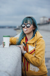 Porträt einer jungen Frau mit blau gefärbtem Haar, die eine verspiegelte Sonnenbrille und eine modische Kapuzenjacke trägt - VPIF00849