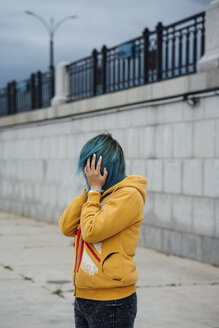 Junge Frau bedeckt ihr Gesicht mit ihrem gefärbten blauen Haar - VPIF00867