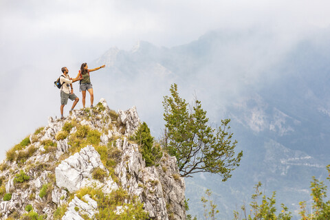 Italien, Massa, Paar steht auf einem Gipfel in den Alpi Apuane, lizenzfreies Stockfoto