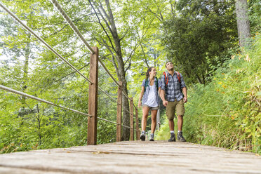 Italy, Massa, young couple hiking and walking on a boardwalk in the Alpi Apuane - WPEF00881