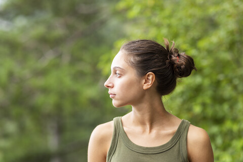 Porträt einer jungen Frau im Freien mit Blick zur Seite, lizenzfreies Stockfoto