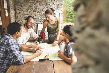 Gruppe von Wanderern, die zusammensitzen und eine Wanderroute planen und dabei die Karte betrachten - WPEF00904