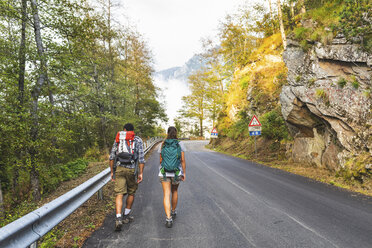 Italien, Massa, Rückansicht eines jungen Paares auf einer asphaltierten Straße in den Alpi Apuane - WPEF00911