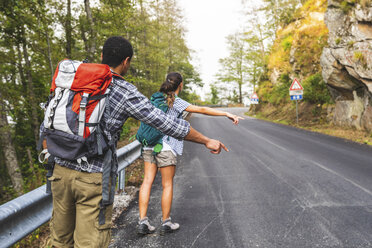 Italy, Massa, couple hitchhiking on a road in the Alpi Apuane mountains - WPEF00914