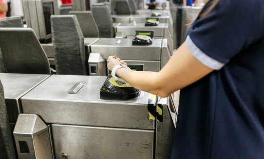 Junge Frau bezahlt mit ihrer Smartwatch in der U-Bahn, Teilansicht - MGOF03800