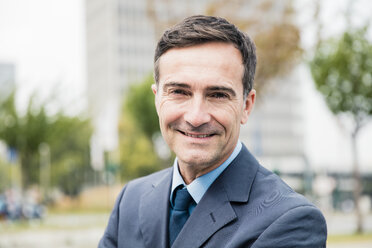 Portrait of smiling businessman in the city - MOEF01431