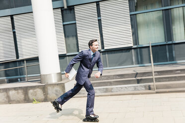 Businessman inline skating in the city - MOEF01437
