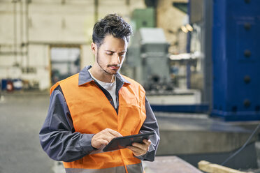 Mann benutzt Tablet in Fabrik - BSZF00601