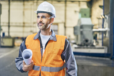 Man holding blueprints in factory looking around - BSZF00605