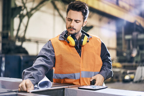 Mann in Arbeitsschutzkleidung bei der Arbeit in einer Fabrik - BSZF00611