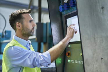 Ingenieur, der Computer benutzt und Maschinen in der Fabrik bedient - BSZF00652