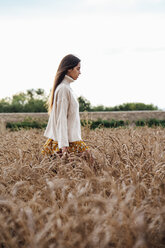 Junge Frau mit übergroßem Rollkragenpullover in einem Maisfeld stehend - VPIF00880