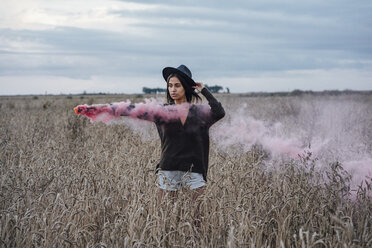Porträt einer jungen Frau in einem Maisfeld mit Rauchfackel - VPIF00897