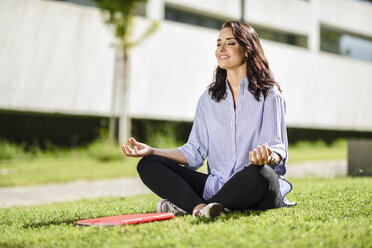 Porträt einer lächelnden Studentin bei Yoga-Übungen auf dem Campus - JSMF00475