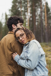 Finnland, Lappland, junges Paar in ländlicher Landschaft stehend - KKAF02089