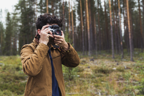 Finnland, Lappland, Mann fotografiert in ländlicher Landschaft, lizenzfreies Stockfoto