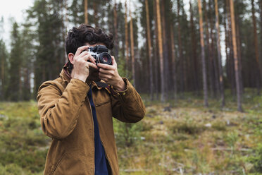 Finnland, Lappland, Mann fotografiert in ländlicher Landschaft - KKAF02090