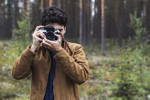 Finnland, Lappland, Mann fotografiert in ländlicher Landschaft, lizenzfreies Stockfoto
