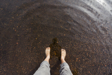 Füße eines Mannes im Wasser eines Sees - KKAF02138