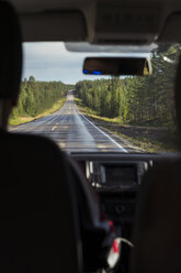 Finnland, Lappland, Innenansicht eines Mannes am Steuer eines Autos in einer ländlichen Landschaft - KKAF02160