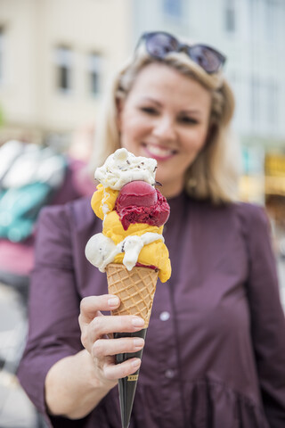 Frau hält Eiswaffel mit verschiedenen Eissorten, lizenzfreies Stockfoto