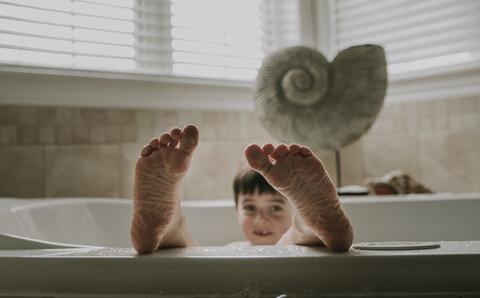Porträt eines Jungen, der ein Bad in der Badewanne nimmt, lizenzfreies Stockfoto
