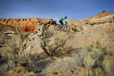 Seitenansicht eines Wanderers beim Mountainbiking in der Wüste - CAVF49097