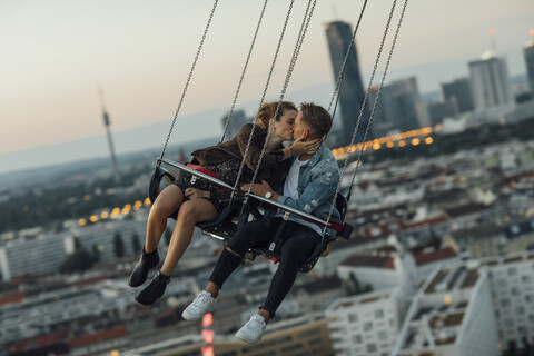 Young couple in love, riding chairoplane on a fairground stock photo