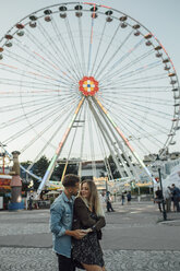 Young couple in love, embracing at a funfair - LHPF00108