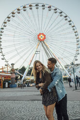 Young couple in love, embracing at a funfair - LHPF00114