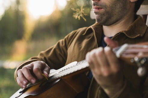 Nahaufnahme eines jungen Mannes, der die Ukulele spielt - KKAF02179