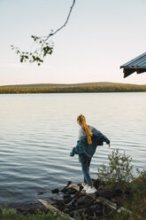 Junge Frau an einem See, auf einer Planke balancierend - KKAF02222