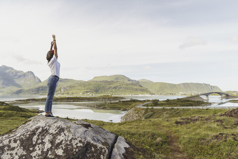 Junge Frau steht in der Natur, streckt sich, Lappland, Norwegen, lizenzfreies Stockfoto