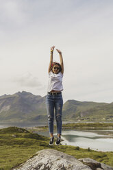 Junge Frau springt auf einen Felsen, Lappland, Norwegen - KKAF02254