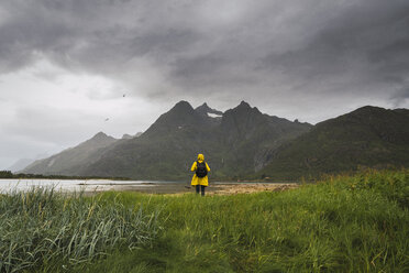 Junger Mann steht an einem See auf der Insel Vesteralen, Lappland, Norwegen - KKAF02276