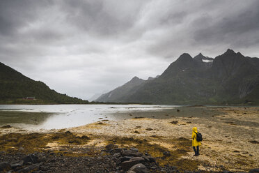 Junger Mann steht an einem See auf der Insel Vesteralen, Lappland, Norwegen - KKAF02277