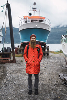 Junger Mann vor einem Schiff, in Regenkleidung, Lappland, Norwegen - KKAF02281