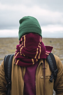 Junger Mann mit Wollmütze und Schal, um das Gesicht gewickelt - KKAF02297