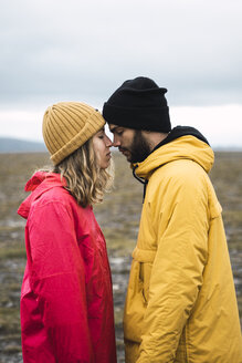 Young couple rubbing affectionately noses, Lapland, Norway - KKAF02299