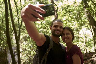 Spanien, Kanarische Inseln, La Palma, lächelndes Paar macht ein Selfie im Wald - PACF00151