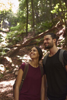 Spanien, Kanarische Inseln, La Palma, lächelndes Paar, das in einem Wald steht und sich umsieht - PACF00154