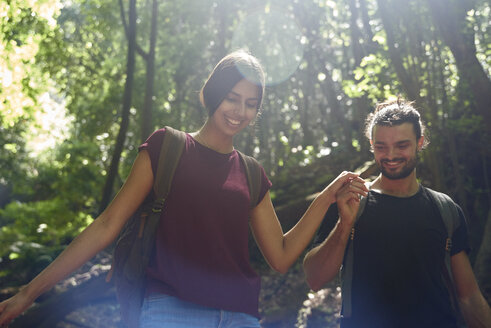 Spanien, Kanarische Inseln, La Palma, lächelndes Paar geht Hand in Hand durch einen Wald - PACF00156