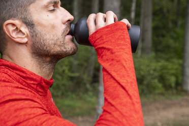 Sportler beim Mountainbiking in der Natur, macht eine Pause, trinkt Wasser - KKAF02368