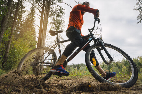 Sportler beim Mountainbiking im Wald, lizenzfreies Stockfoto