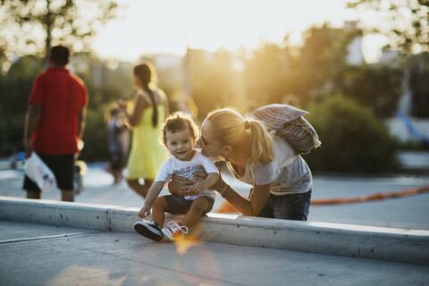 Happy mother with her little son on a square at sunset stock photo