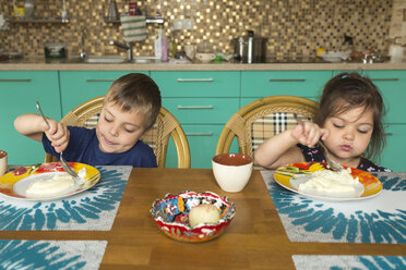 Porträt eines Jungen und seiner kleinen Schwester beim Frühstück in der Küche - VGF00003