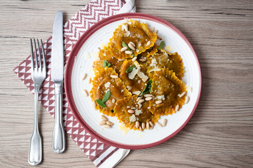 Plate of pumpkin ravioli with sage leaves, parmesan and pine nuts - GIOF04550